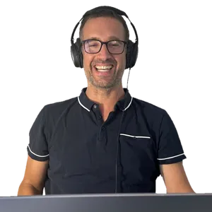 Yann teaching a French session over video call, headphones on, laughing at something a student said